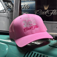 Cool Flo Surf Bus trucker cap in pink featuring embroidered Surf Bug artwork and breathable mesh back panels, positiond on a classic car.