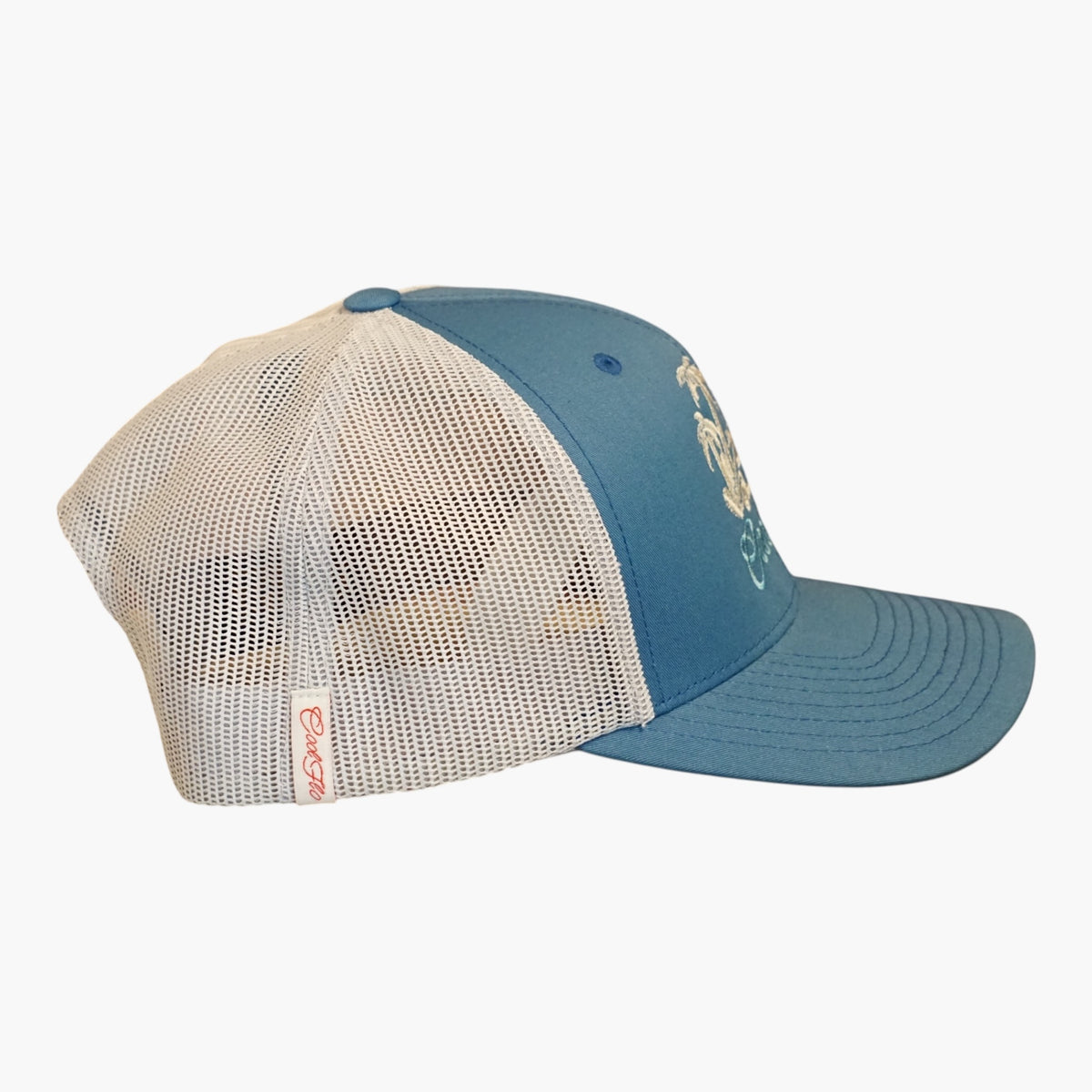 Side view of a Cool Flo Blue/Silver Surf Bus trucker cap featuring breathable mesh back panels, a Cool Flo loop tag and adjustable snapback fastener