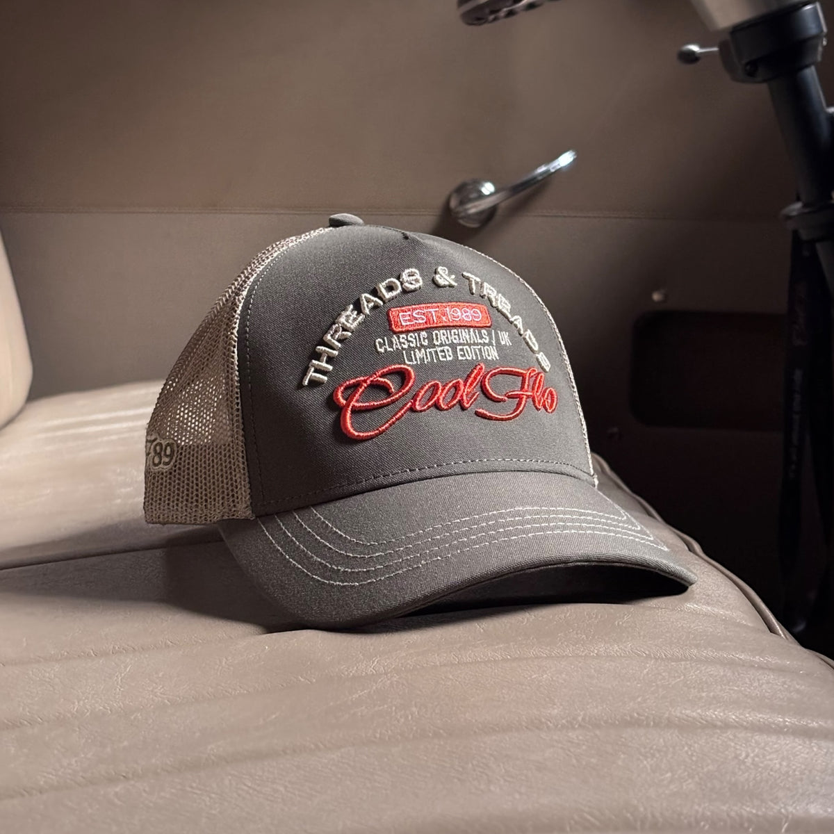 Front view of a Cool Flo Threads & Treads trucker cap in Olive/Khaki featuring embroidered Threads & Treads artwork with a structured front panel and curved visor