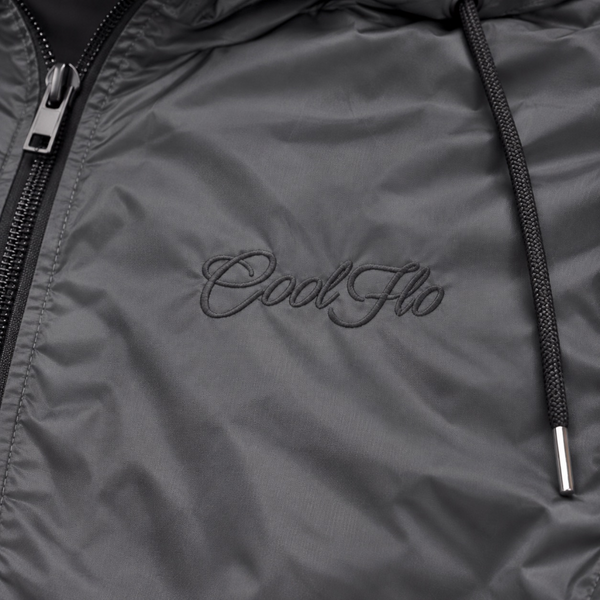 Close-up of tonal Cool Flo Script embroidery on the dark grey Wind Runner Jacket.